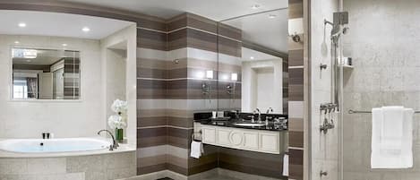 A modern bathroom with a freestanding bathtub, a vanity with a mirror, and a walk-in shower.