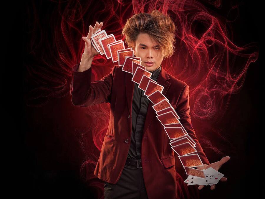 Una persona con traje rojo sosteniendo una carta de juego.