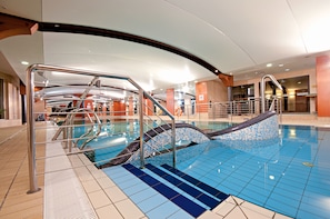 An indoor swimming pool with clear water, metal railings, and tiled flooring. - Łeba Hotel & Spa (Leba)