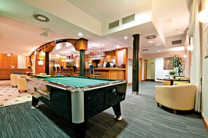 A pool table in a hotel lobby with a bar area and seating. - Łeba Hotel & Spa (Leba)