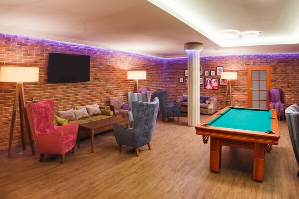 A cozy room with a pool table, a sofa, and two armchairs. - Masuria Hotel & Spa (Lukta)