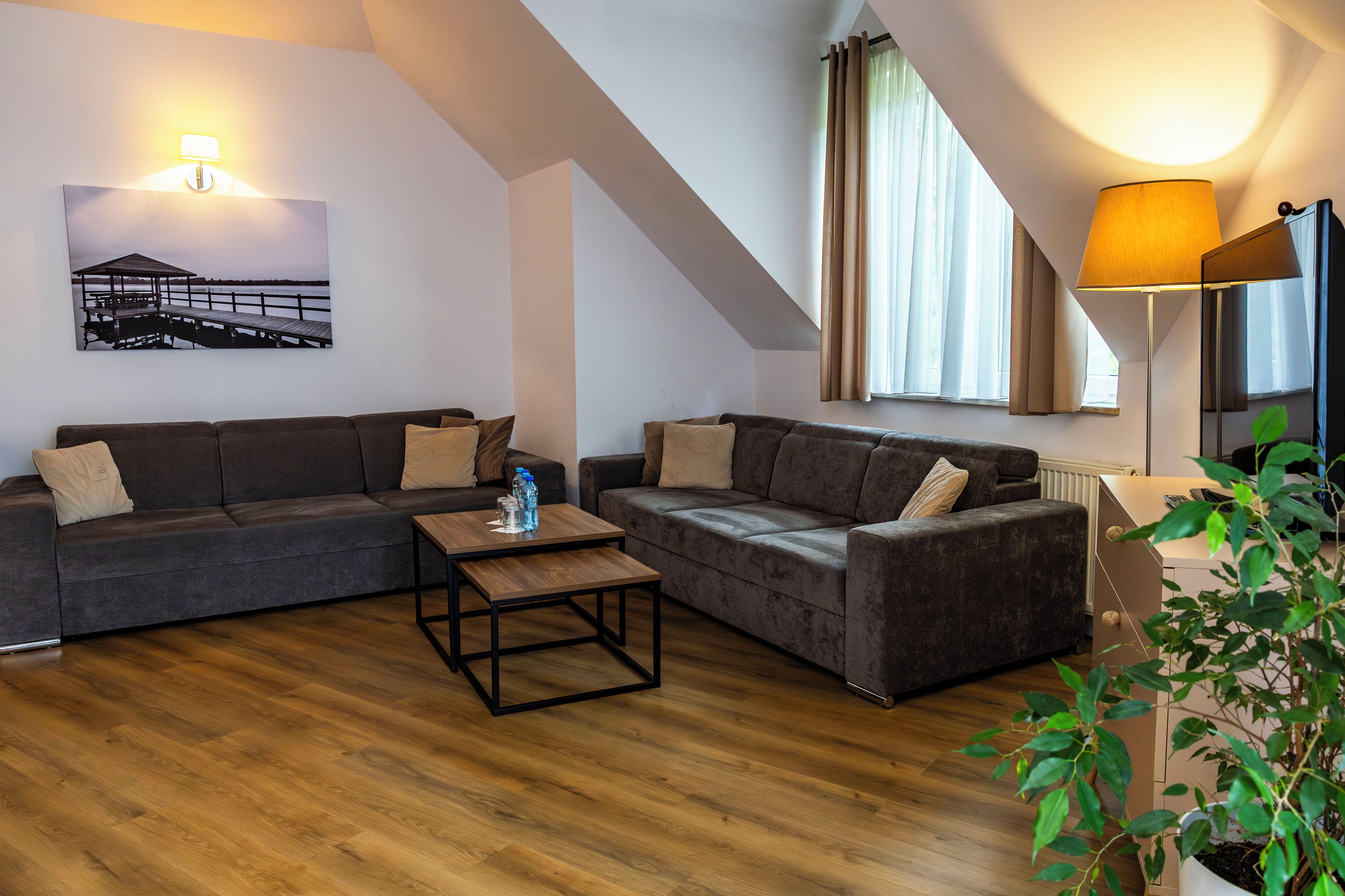 Ein modernes Wohnzimmer mit zwei Sofas, einem Couchtisch und einem Gemälde an der Wand.