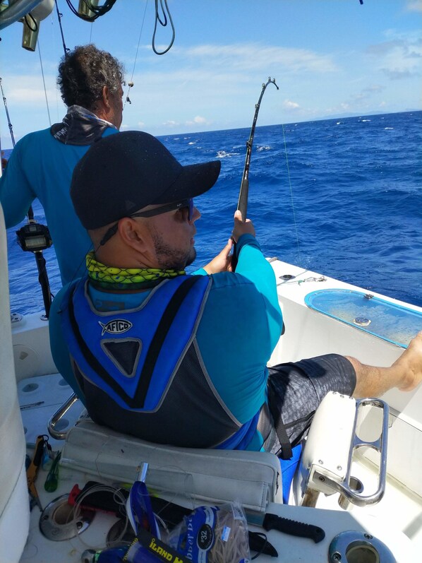 A person on a boat holding a fishing rod.