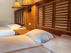 A hotel room with two single beds, a small table, and a wall-mounted lamp. - Hotel Granada (Granada)