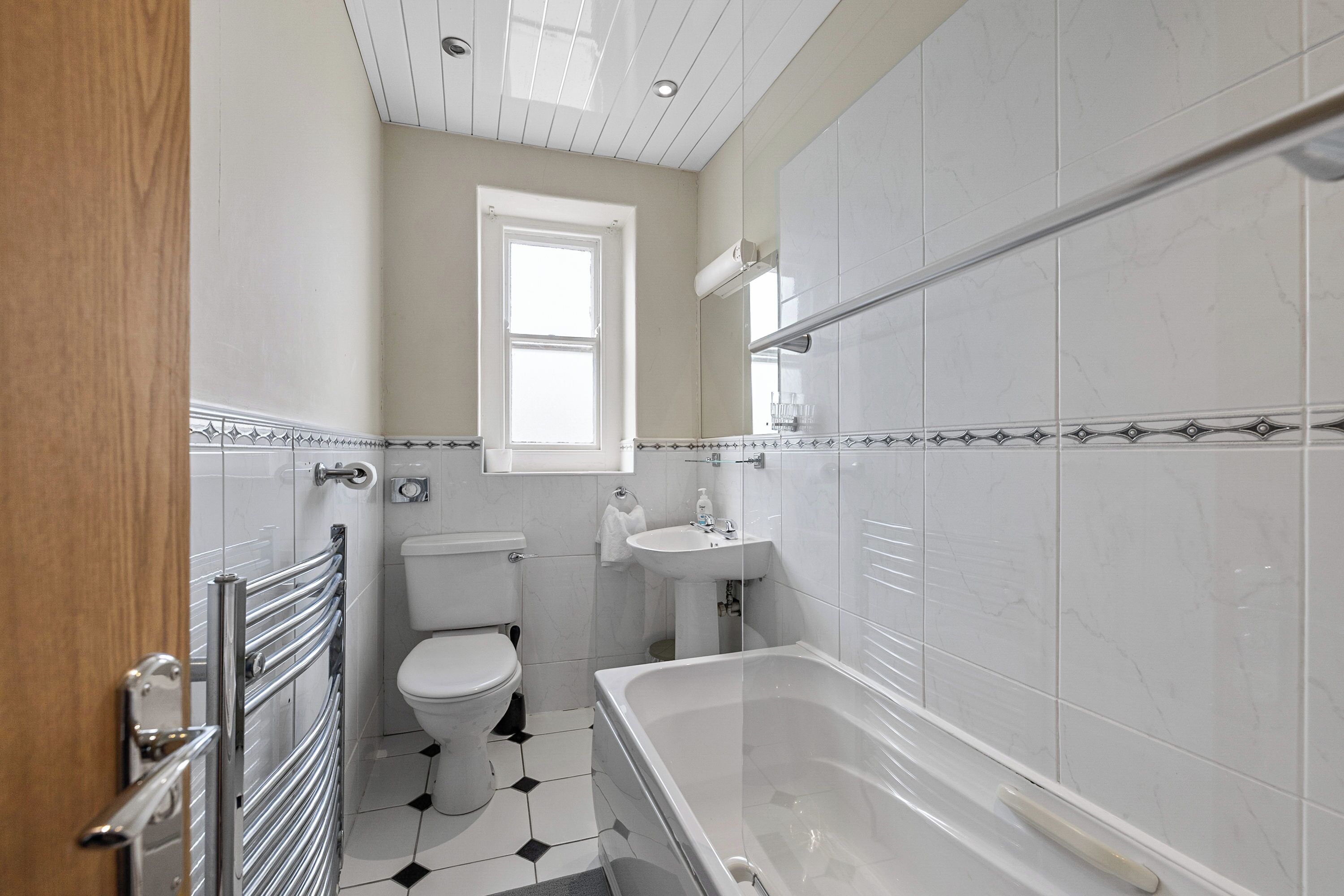 A bathroom with a toilet, sink, and bathtub.