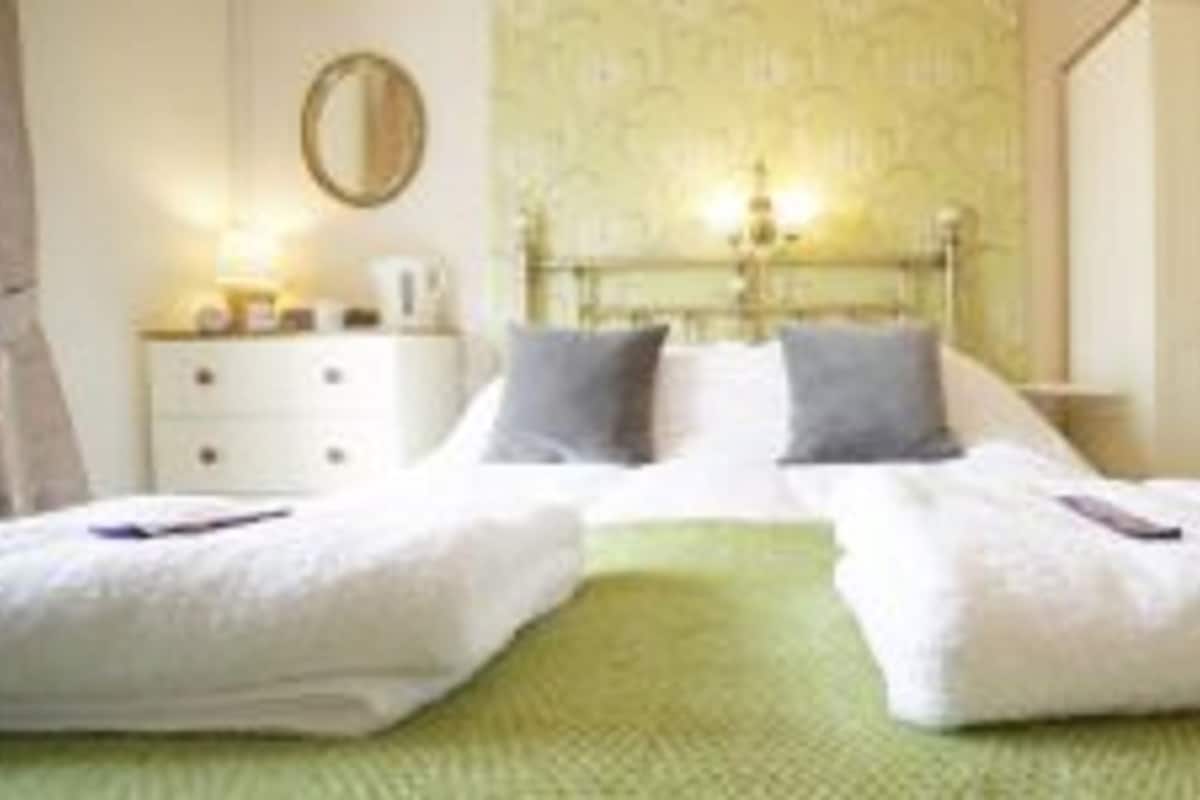 A double bed with two pillows, a bedside table with a lamp, and a wardrobe.