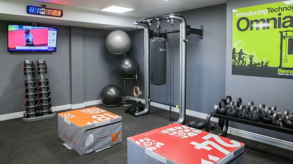 A gym with exercise equipment, a TV, and a banner advertising Omni Health Club & Spa.