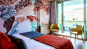 A hotel room with a bed, a large window, and a view of the outside.