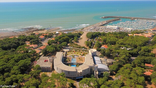 An aerial view of a coastal hotel with a marina, beach access, and lush greenery. - Club Vacances Bleues Les Jardins Atlantique (Talmont-Saint-Hilaire)