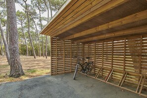 A covered wooden structure with a bicycle rack and a bench. - Club Vacances Bleues Les Jardins Atlantique (Talmont-Saint-Hilaire)