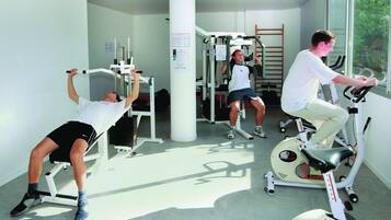 Une salle de sport équipée de matériel d’exercice, avec une fenêtre et une échelle.