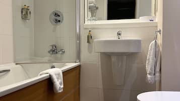 A modern bathroom with a glass-enclosed shower, a wooden vanity, a white sink, and a toilet.