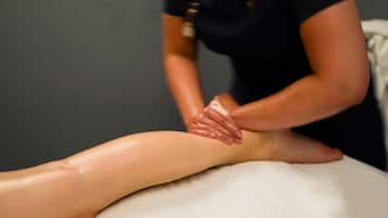 Sesión de masoterapia en curso sobre una camilla.