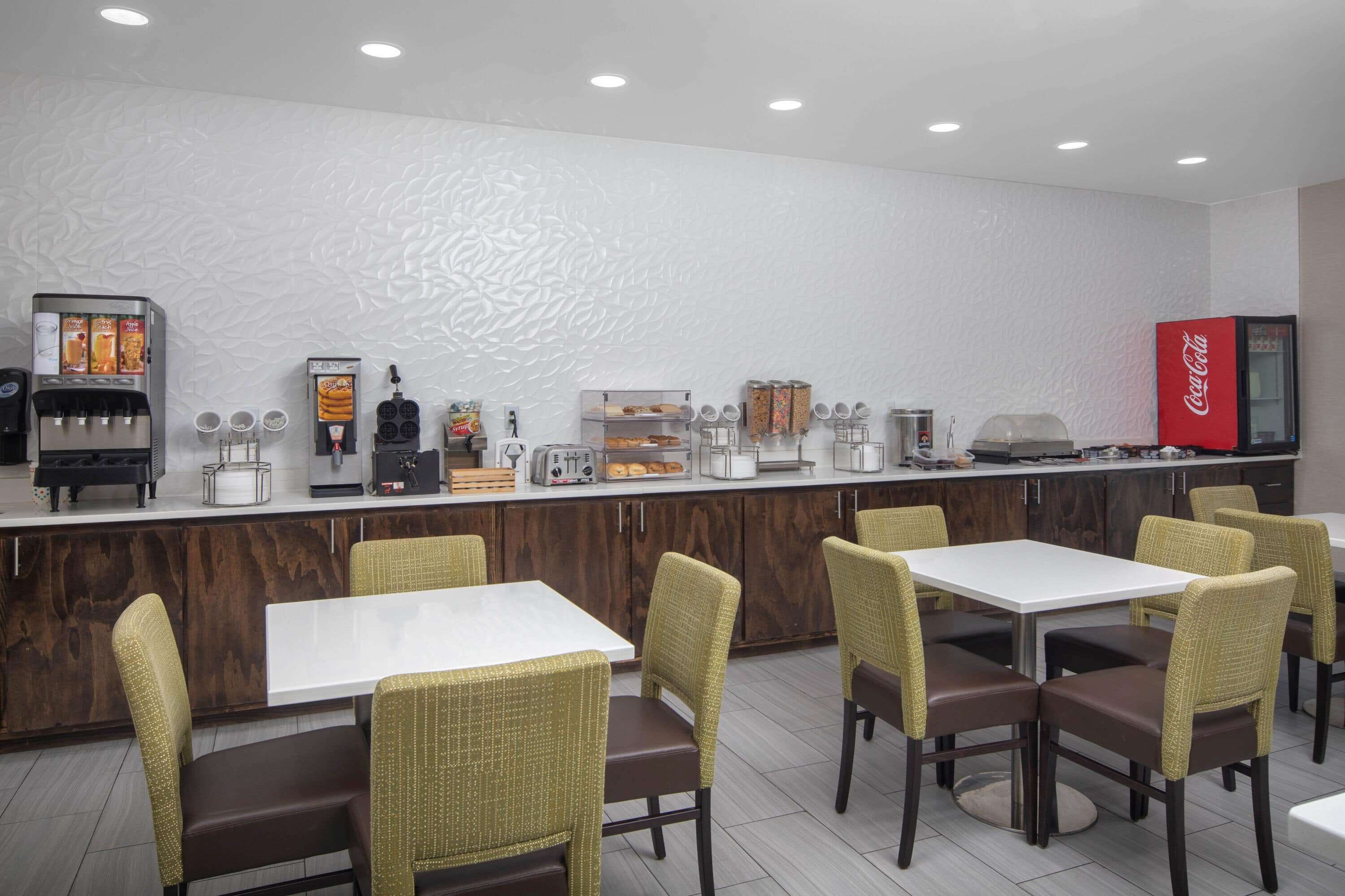 A restaurant with a counter, seating area, and various food and beverage stations.