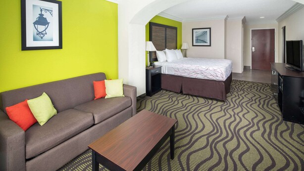 Une chambre d’hôtel avec un lit, un canapé, une télévision et un bureau.