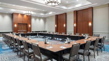 A conference room with a long table, chairs, and a chandelier.