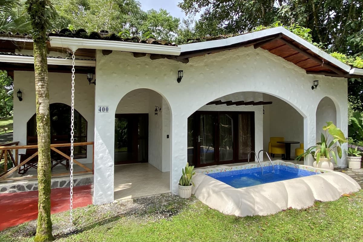 A building with a pool, covered patio, and arched doorways.