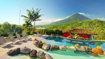 Una piscina al aire libre, sillones reclinables de piscina