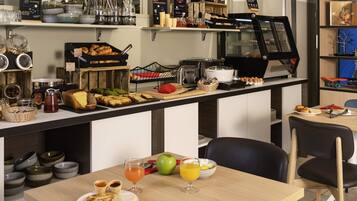 A breakfast buffet with various food items and a coffee station.