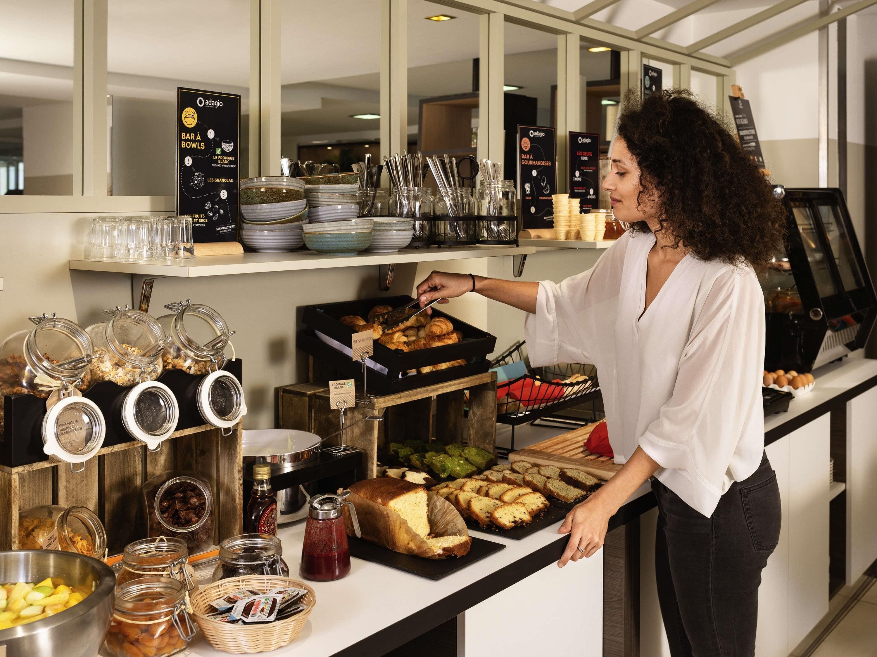 Un'area buffet con diverse pietanze, tra cui frutta, pasticceria e condimenti.