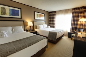 A hotel room with two beds, a desk, a chair, and a lamp. - Isle Casino Hotel Bettendorf - A Caesars Rewards Destination (Bettendorf)