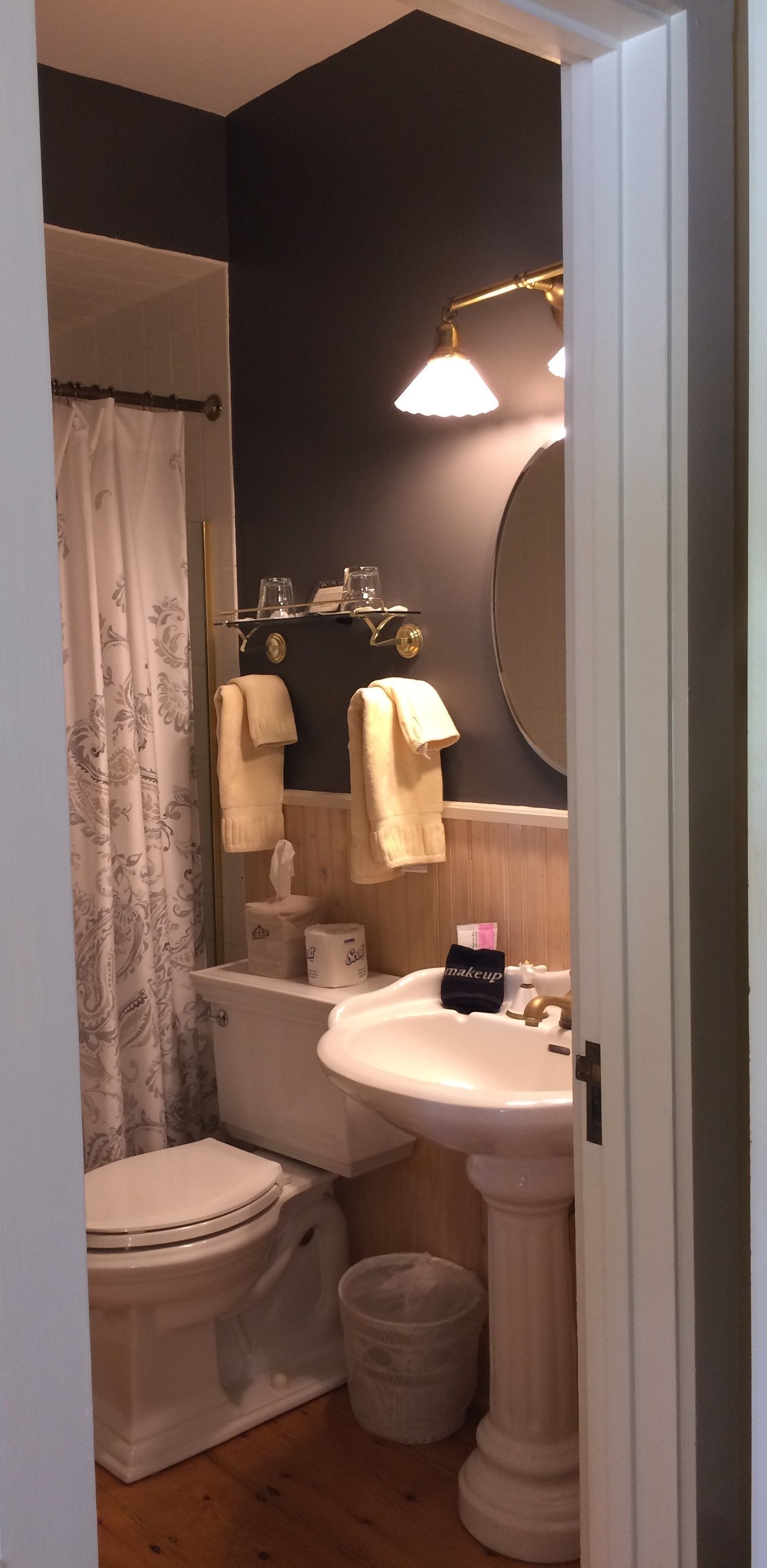 A bathroom with a toilet, sink, and shower.
