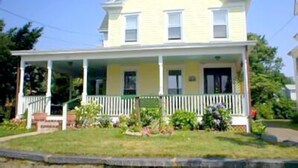 A two-story house with a porch and a small garden.