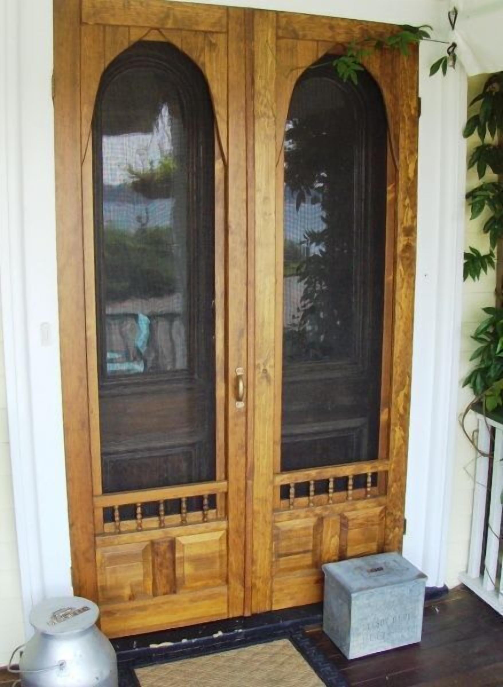 A wooden double door with glass panels and a small step leading up to it.