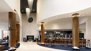 A spacious lobby with a bar area, seating, and a fireplace. - Courtyard by Marriott Atlantic City Beach Block (Atlantic City)