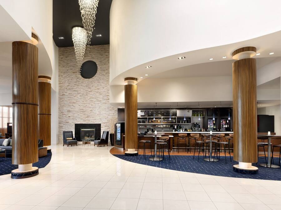 A spacious lobby with a bar area, seating, and a fireplace.