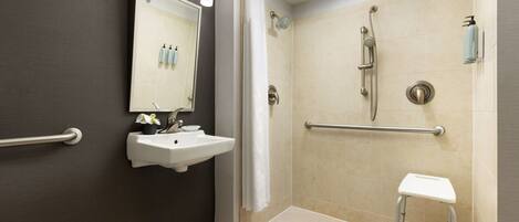 A modern bathroom with a shower, a sink, and a mirror.