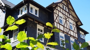 Un edificio tradicional con entramado de madera y múltiples ventanas, con un letrero que indica que es un hotel.