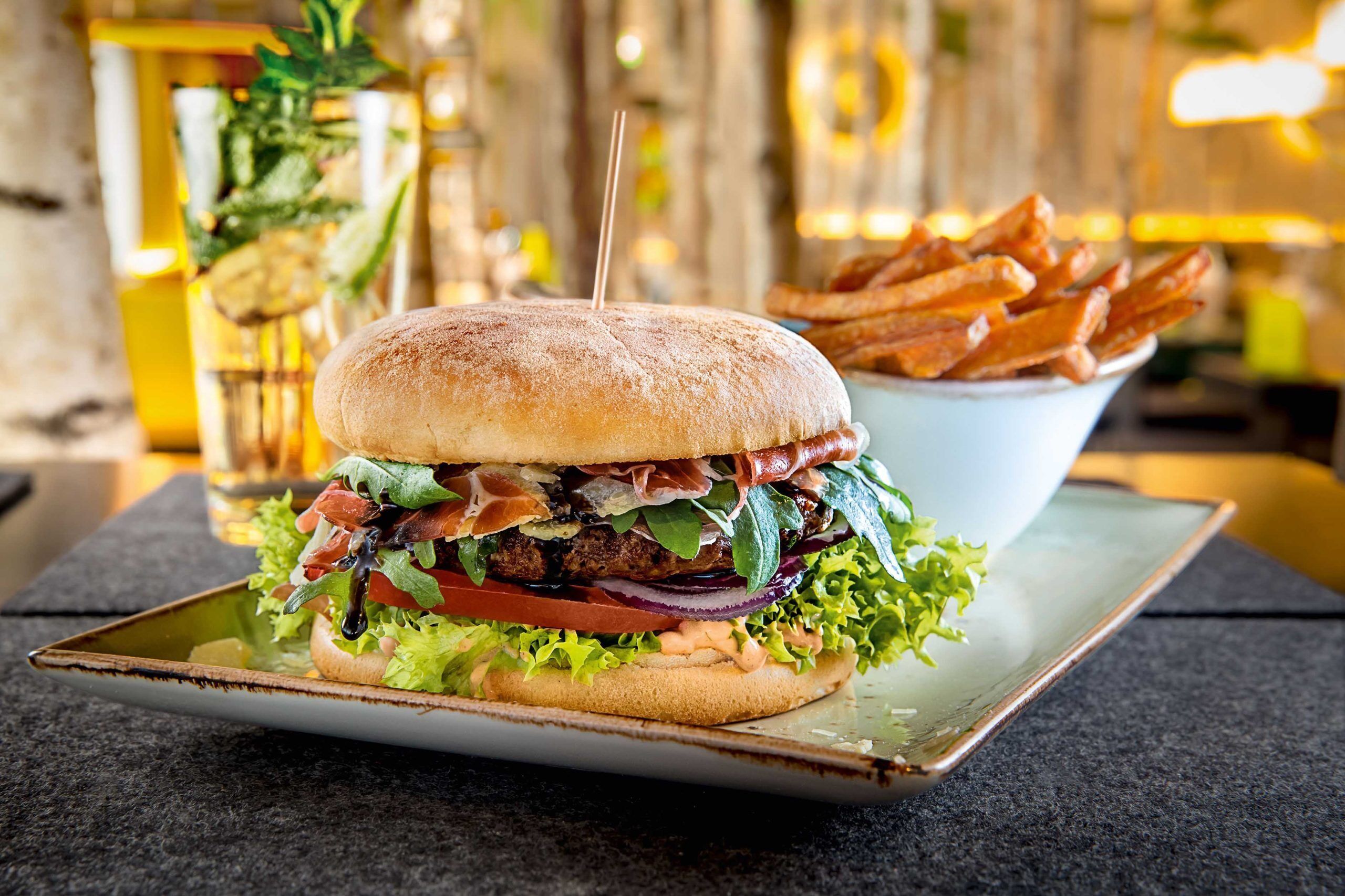 A burger with fries on a plate.