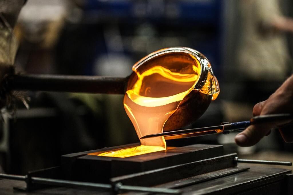 Une personne travaillant avec du métal en fusion dans un atelier.