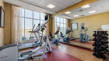A gym with treadmills, elliptical machines, and weight machines.