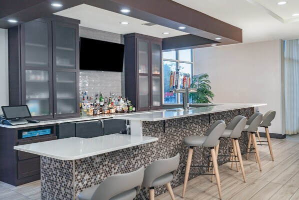 A modern kitchen with a bar area, including a countertop with bar stools and a laptop. - Holiday Inn Southaven Central - Memphis by IHG (Southaven)