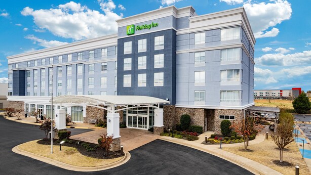 A Holiday Inn hotel with a modern design, featuring a covered entrance, a parking lot, and landscaped areas. - Holiday Inn Southaven Central - Memphis by IHG (Southaven)