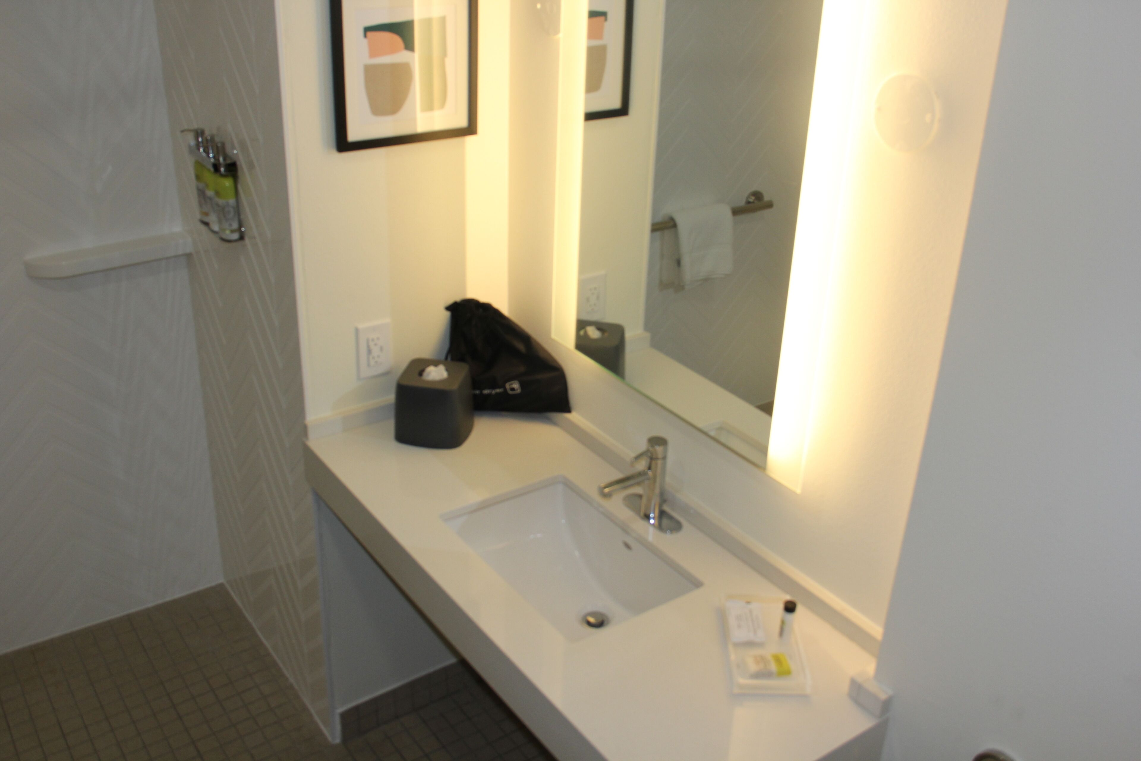 A bathroom with a white sink, a mirror, and a towel rack.