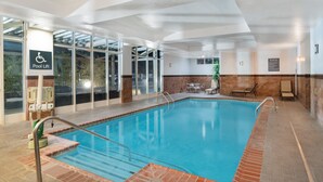 An indoor swimming pool with clear water, a pool lift, and a seating area with chairs and a table. - Holiday Inn Southaven Central - Memphis by IHG (Southaven)
