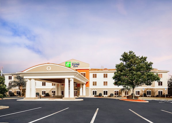 A Holiday Inn Express & Suites with a central entrance, parking lot, and surrounding greenery. - Holiday Inn Express Hotel & Suites Inverness by IHG (Lecanto)