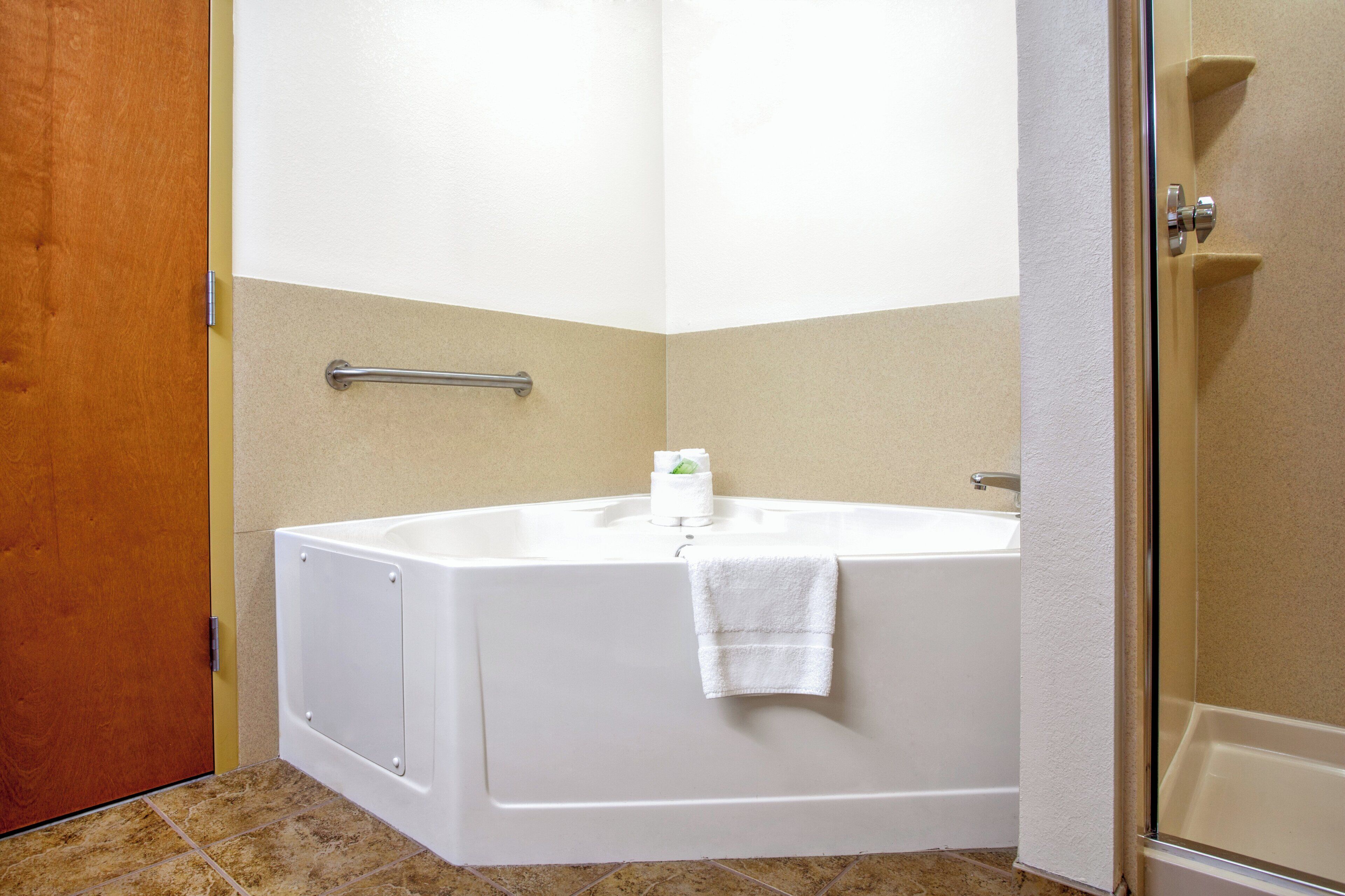 Un baño con una bañera blanca, una toalla colgada al lado y una zona de ducha.