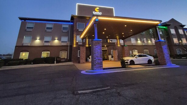 A hotel with a covered entrance, a sign reading 'Comfort,' and a white car parked in front. - Comfort Inn & Suites Miami - Route 66 (Miami)