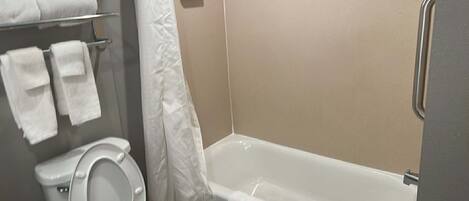 Un baño con inodoro, bañera y cortina de ducha.