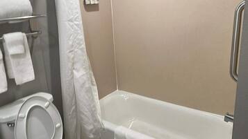 A bathroom with a toilet, a bathtub, and a shower curtain.