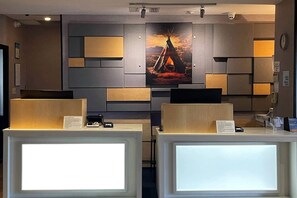A reception area with a modern design, featuring a large painting of a teepee on the wall, a reception desk, and a clock on the wall. - Comfort Inn & Suites Miami - Route 66 (Miami)