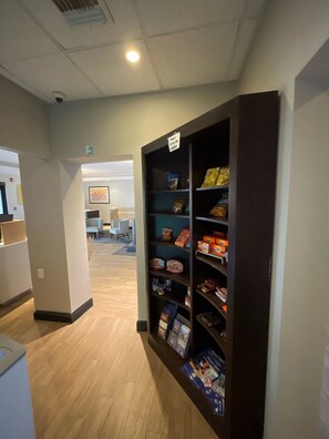 A hallway with a snack vending machine and a sign indicating a tour on camera. - Comfort Inn & Suites Miami - Route 66 (Miami)