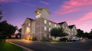 A Suburban Studios hotel with a brick facade and a prominent sign. - Suburban Studios Denver Central-Arvada (Arvada)