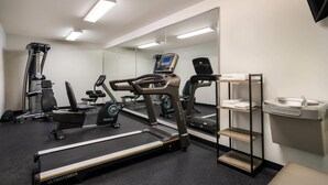 A gym with treadmills, a rowing machine, and a mirrored wall. - Suburban Studios Denver Central-Arvada (Arvada)