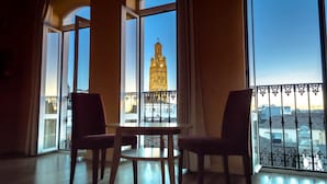 A room with a table and two chairs, large windows with a view of a tower. - Hotel 4* Mirador de Llerena (Llerena)