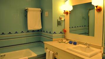 Une salle de bain avec une baignoire, un lavabo et un miroir.